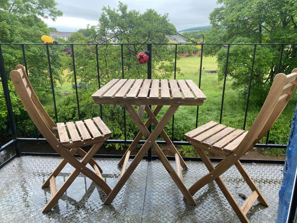 - Balcón con mesa de madera y 2 sillas en Riverbank Cottage Lake District Double Balcony en Egremont