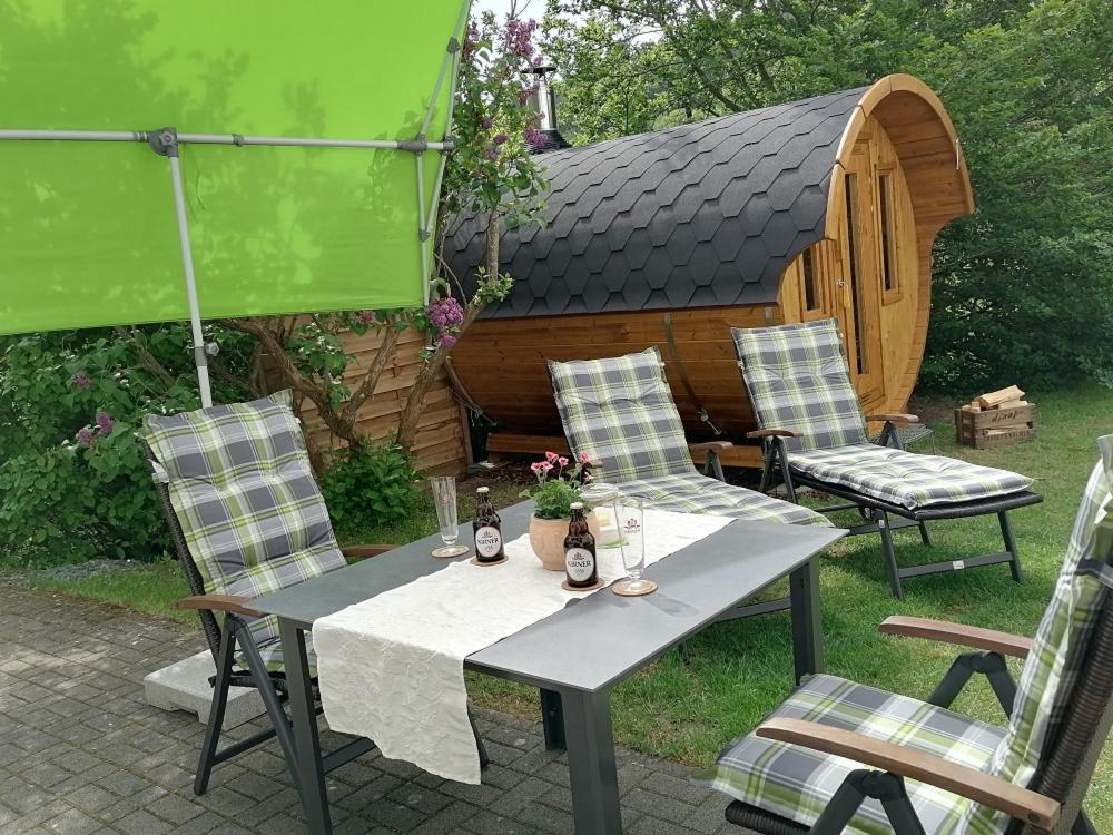 a table and chairs with a house in the background at Ferienwohnung Siegel in Heimweiler