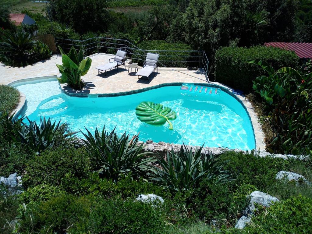 a swimming pool in a yard with two lounge chairs at Relax tiny villas 40 meters of the beach in Korčula