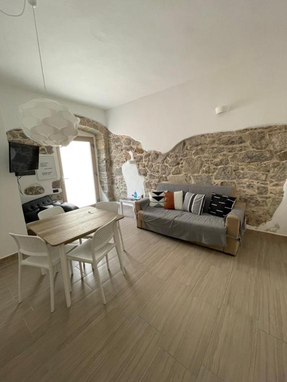 ein Wohnzimmer mit einem Sofa und einem Tisch in der Unterkunft APPARTAMENTO S.ANTIOCO in SantʼAntìoco