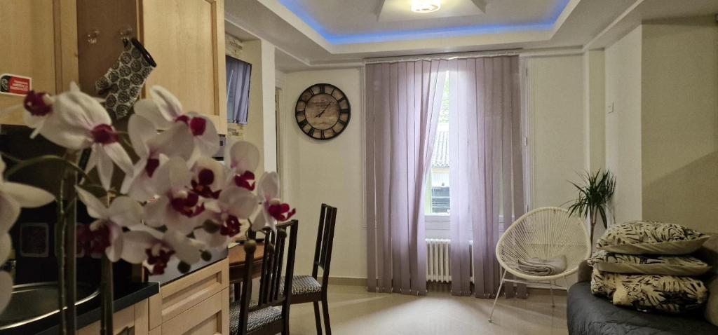 een woonkamer met een tafel, een raam en bloemen bij Aeroport d Orly paris Rungis Thiais in Thiais