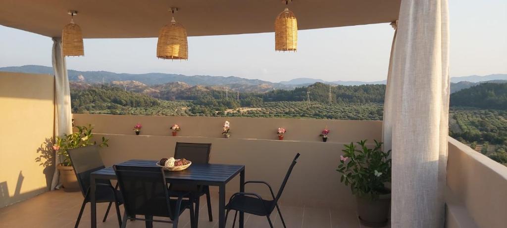 a blue table and chairs on a balcony with a view at Anna's House Theologos in Theologos