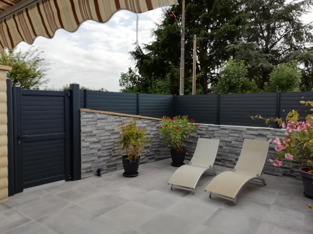 une terrasse avec 2 chaises et une clôture dans l'établissement au coeur des coteaux du Layon, à Le Champ-sur-Layon
