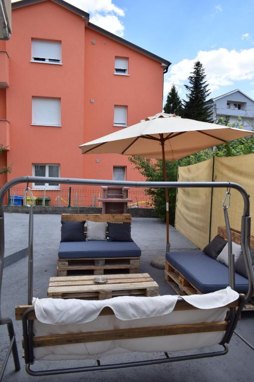 a patio with two chairs and an umbrella at Apartment MAIO in Viskovo