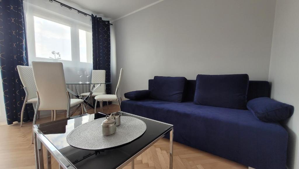 ein Wohnzimmer mit einem blauen Sofa und einem Tisch in der Unterkunft Lovely flat in heart of Wroclaw in Breslau