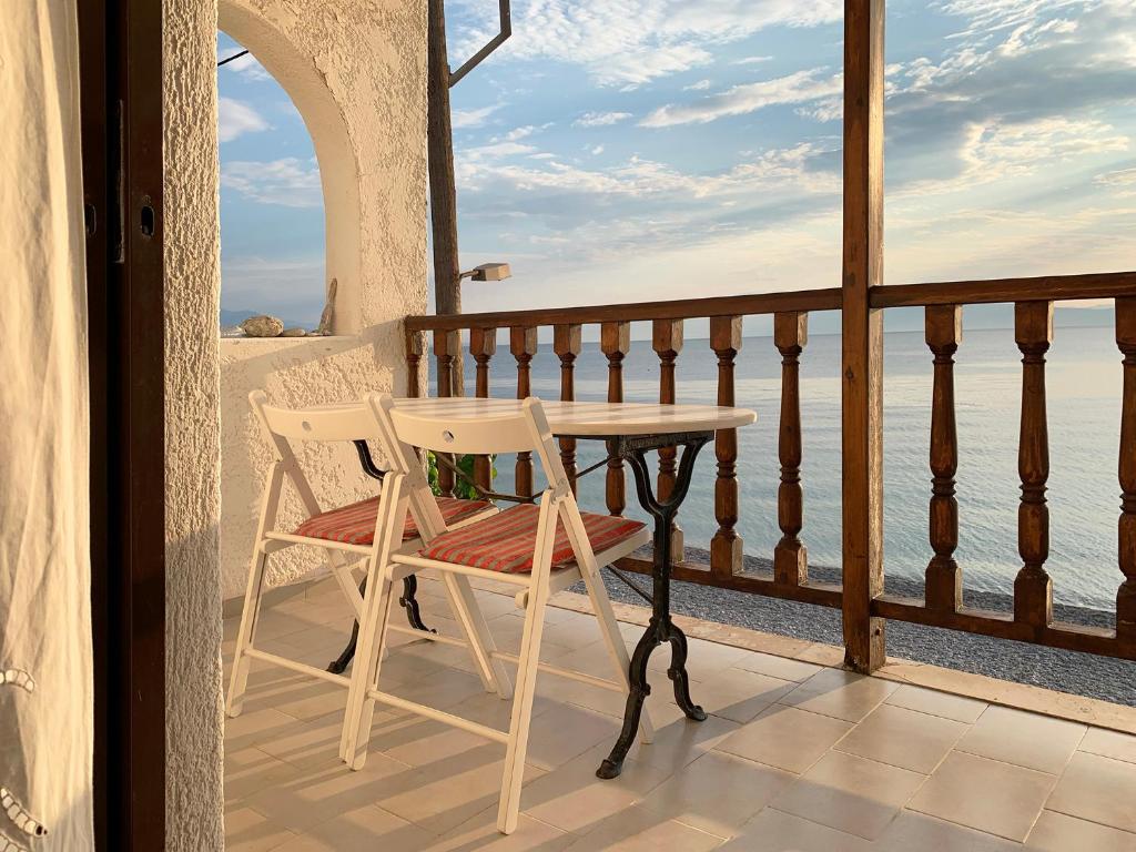 uma mesa e uma cadeira sentadas numa varanda em A Place of Philoxenia em Aíyira