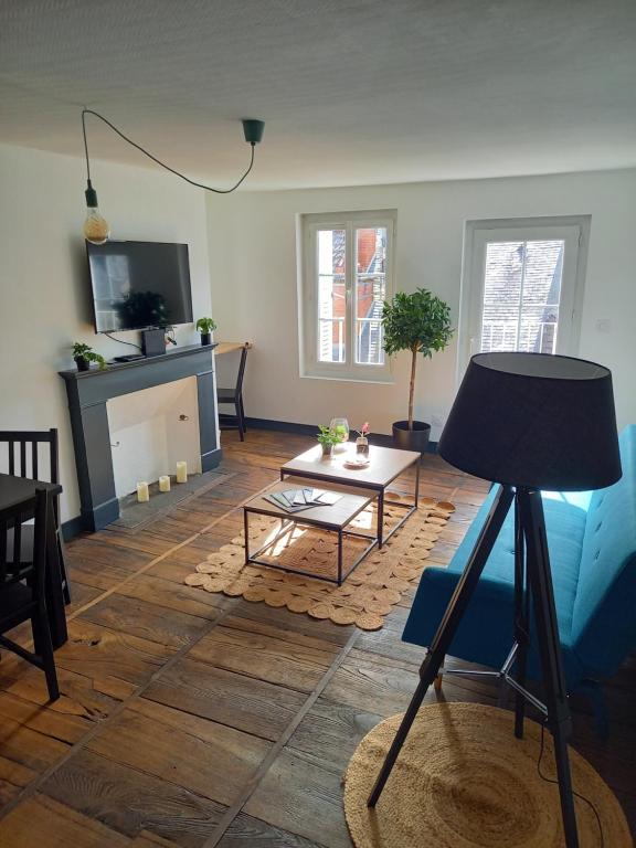 uma sala de estar com uma mesa e uma lareira em Appartement 3 pièces centre ancien de tulle em Tulle