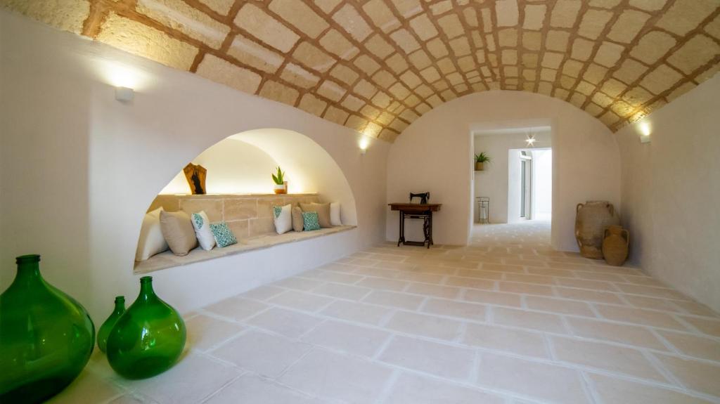 pasillo con techo de piedra y jarrones en el suelo en Corte Sant'Oronzo en Diso