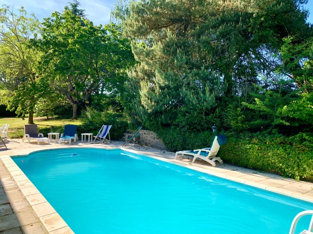 uma grande piscina com espreguiçadeiras em La Ferme Familiale em Faverolles