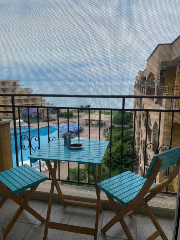 アヘロイにあるBeautiful sea view apartment in Midiya Family Grand Resort, Aheloyのバルコニー(青いテーブル、椅子、プール付)