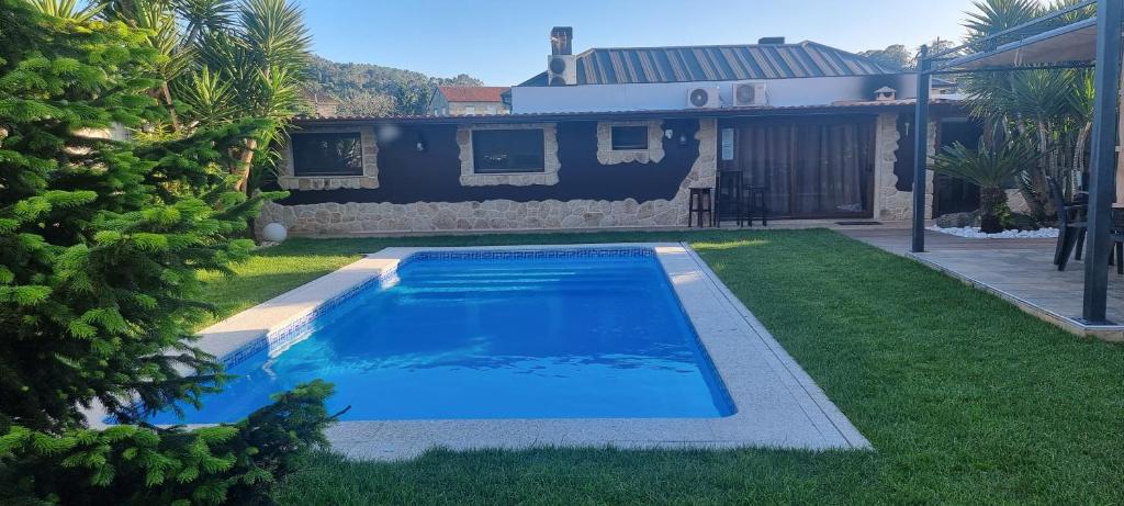 a swimming pool in the yard of a house at CASA JARDIN in Vilagarcia de Arousa