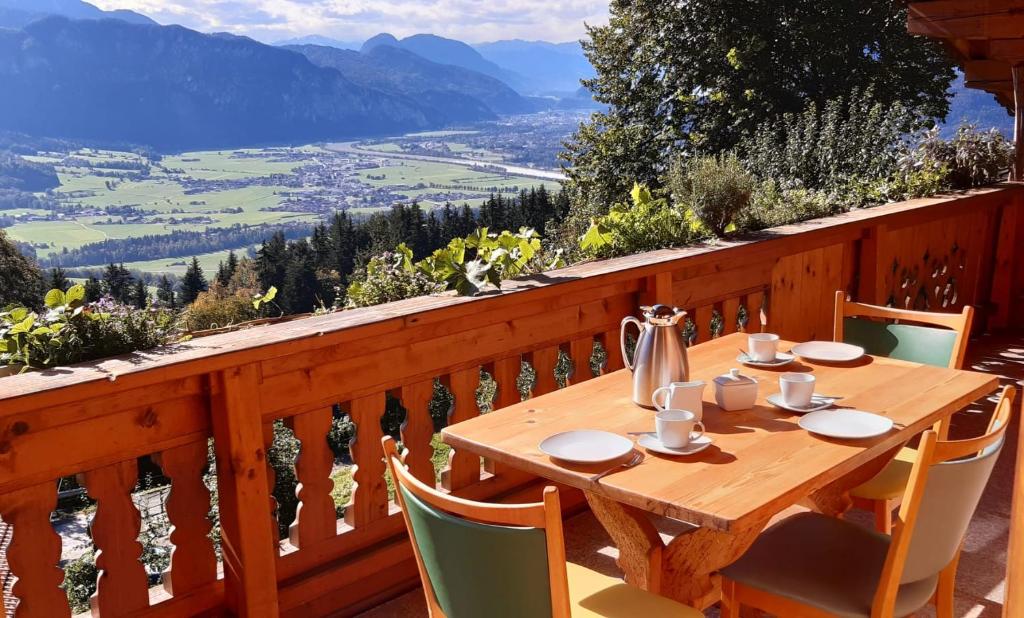 a wooden table and chairs on a balcony with a view at FEWO Niederndorferberg in Niederndorferberg