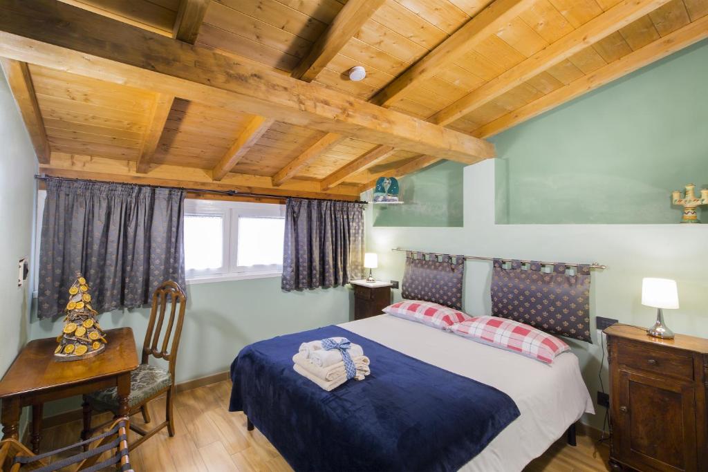 1 dormitorio con cama y techo de madera en Alla Porta Di Sotto B&B en Fivizzano