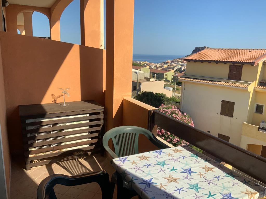 einen Balkon mit einem Tisch und einem Stuhl auf dem Balkon in der Unterkunft Appartamento Incanto Castelsardo Sardegna in Castelsardo