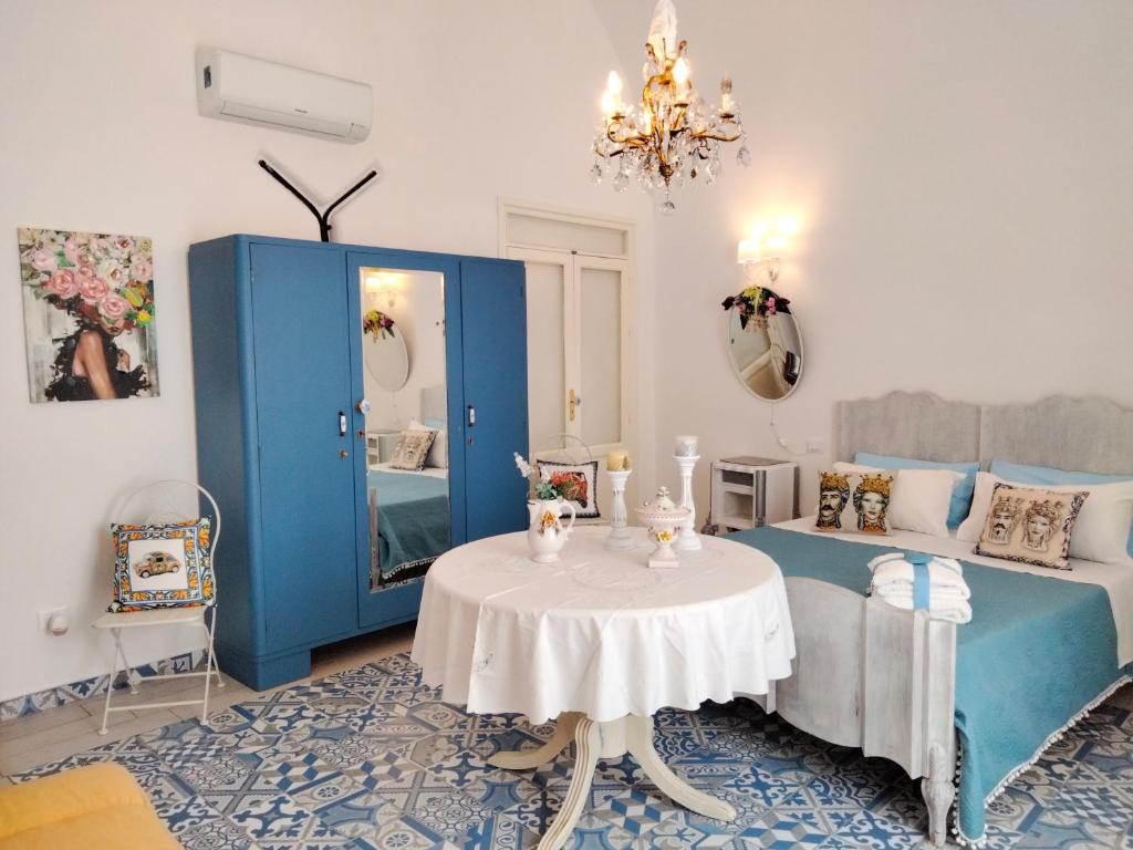 una camera da letto con tavolo, letto e specchio di Le Lanterne di Terrasini a Terrasini