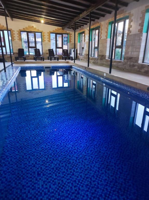 a large swimming pool with blue water in a building at Аура Карпат in Slavske