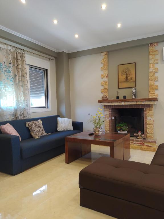 a living room with a blue couch and a fireplace at Just Constructed! in Gastoúni