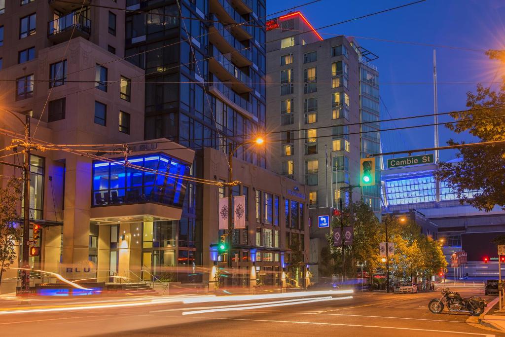 a city street at night with traffic lights and tall buildings at Hotel BLU in Vancouver