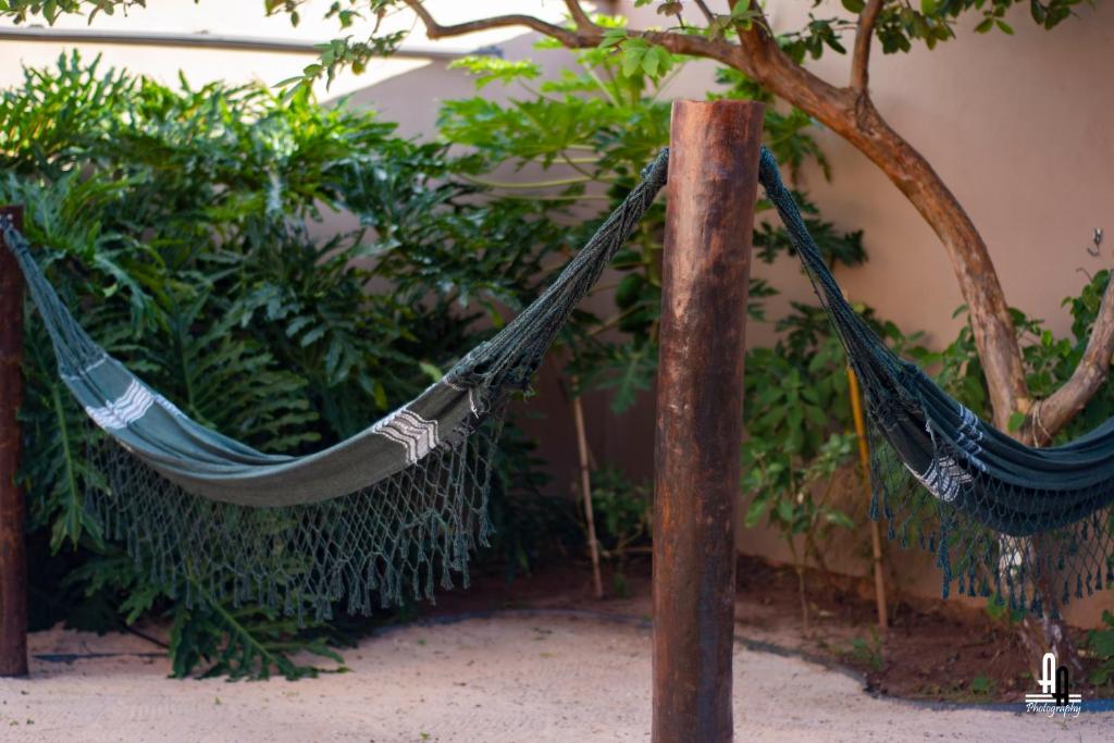two hammocks hanging from a pole in a garden at Ashram Anandini in Campinas