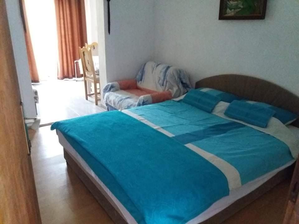 a bed with a blue comforter in a bedroom at Apartment’s Maric - Zelenika,Herceg Novi in Zelenika