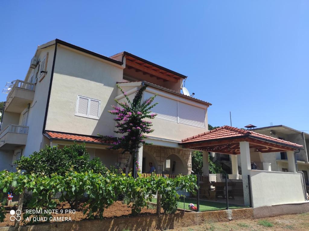 una casa con un árbol delante de ella en Villa Antonio, en Jelsa