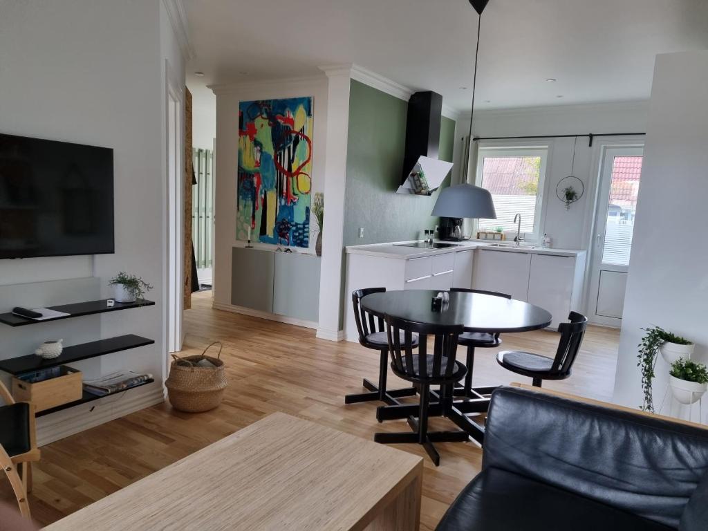 uma sala de estar com uma mesa e uma cozinha em Løkken centrum ferielejlighed-apartment 4E em Lokken
