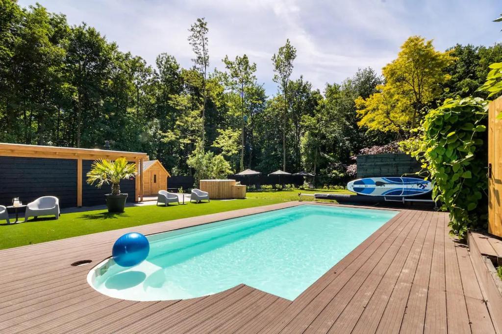 una piscina en un patio trasero con terraza de madera en Glamping lodge with Eco-Wellness en Zeewolde