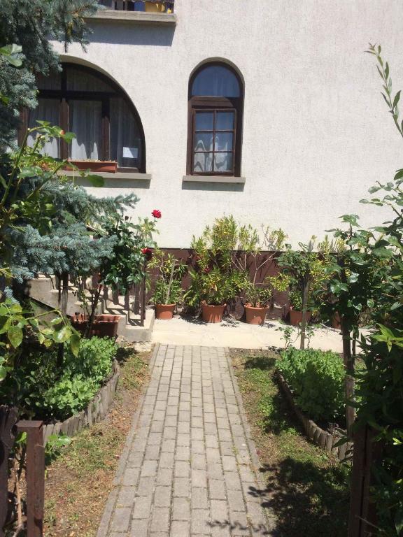 przejście przed budynkiem pełnym roślin w obiekcie Apartment Orvenyes 1 w mieście Örvényes