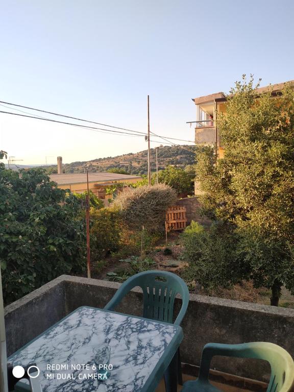 a table and chairs on a balcony with a view at Affittacamere Cooperativa Olistica in Mamoiada