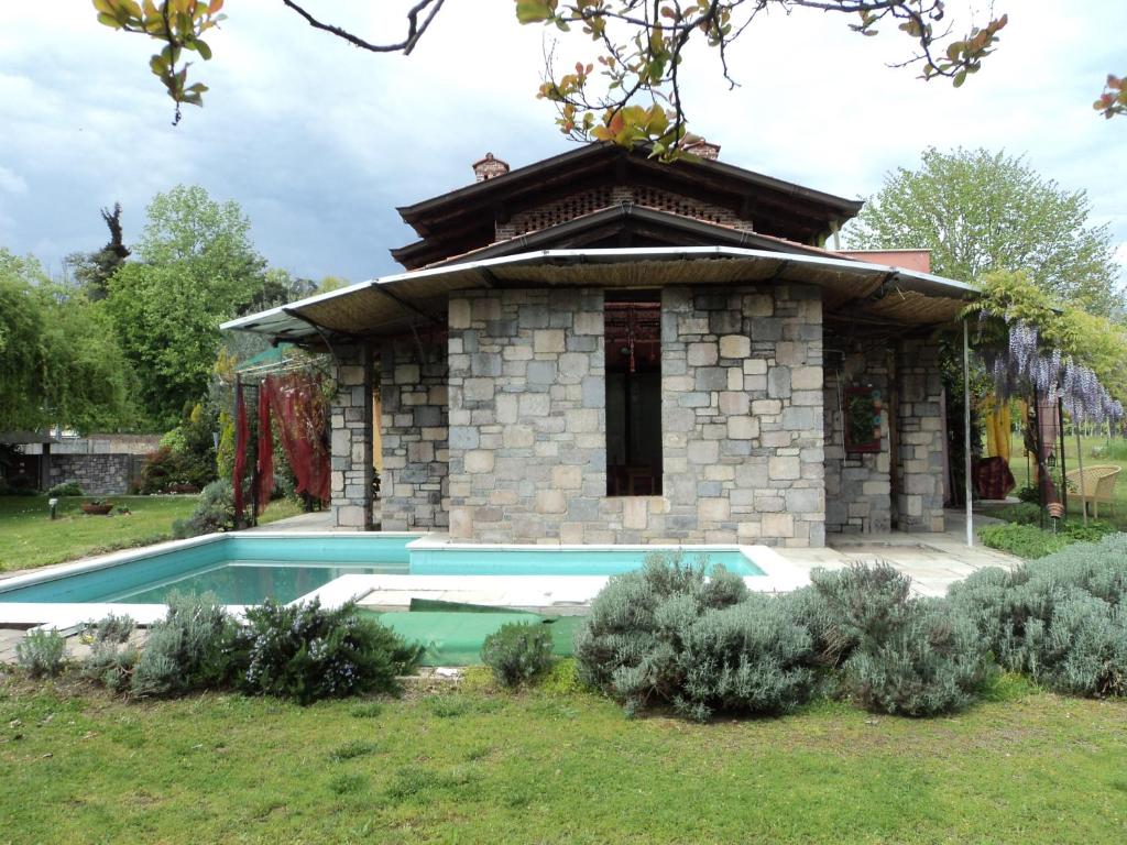 un edificio de piedra con un patio con piscina en B&B La Colombera, en Lessona