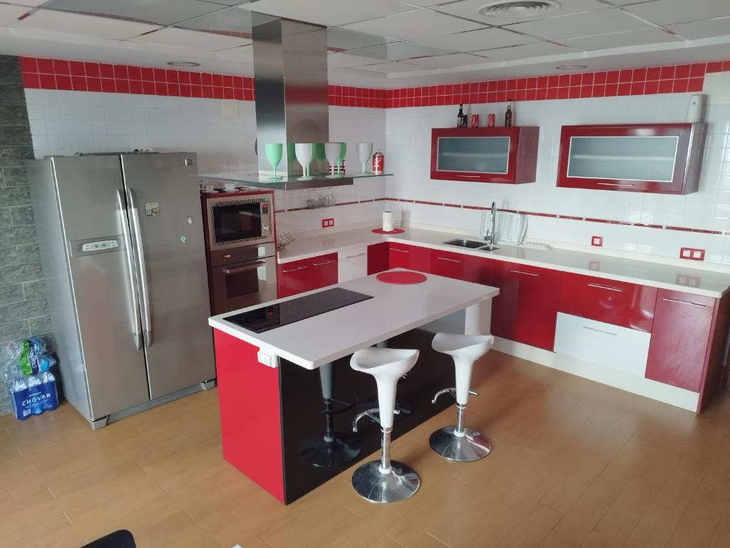 a kitchen with red cabinets and a white counter top at LA MANCHEGUITA DE MADRIGUERAS 5 DORMITORIOS DOBLES CHALET CON PISCINA Y BARBACOA ideal familias 11 personas 