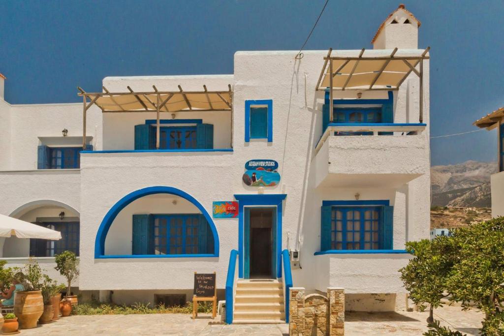 - un bâtiment blanc avec des portes et des fenêtres bleues dans l'établissement Aegean View Studios, à Lefkos Karpathou