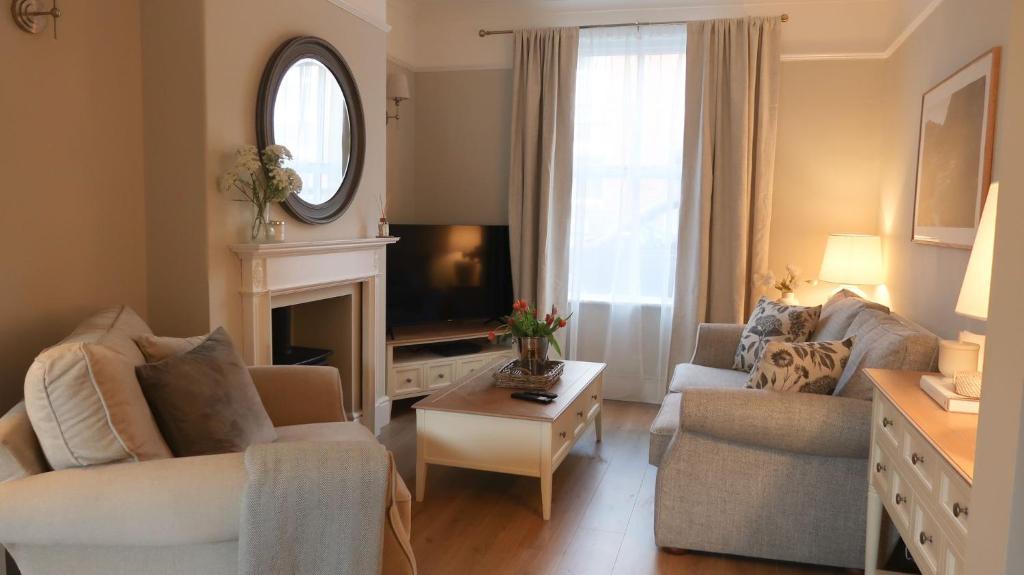 uma sala de estar com duas cadeiras e uma televisão em Luxury living outside the city walls - sleeps six! em Chester