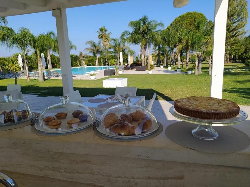 - une table avec trois assiettes de pâtisseries et un gâteau dans l'établissement Tenuta Espada Luxury Residence, à Gallipoli