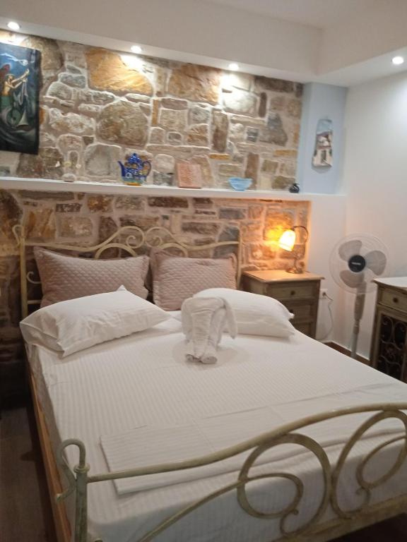 a bed in a room with a stone wall at Artistic house in Kokkari
