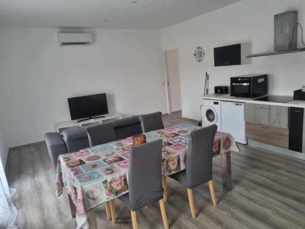 a dining room with a table and chairs and a kitchen at Appartement séjour , cure Cransac au 1er étage 2 nuits minimum in Cransac