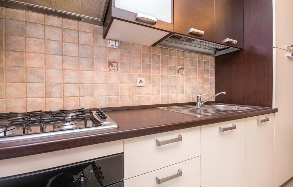 a kitchen with a stove and a sink at Apartmani Andrija in Pakoštane
