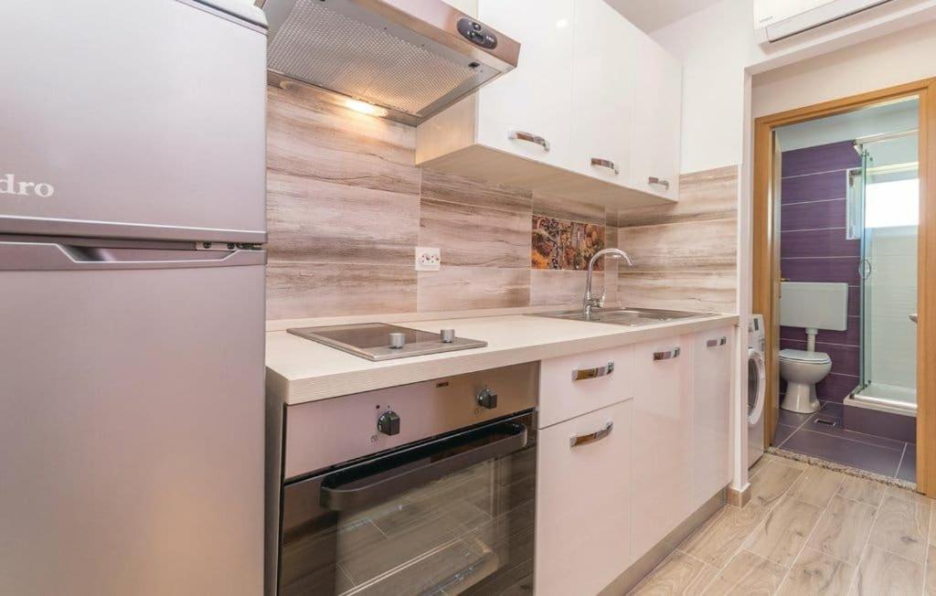 a kitchen with a sink and a stove top oven at Apartmani Andrija in Pakoštane