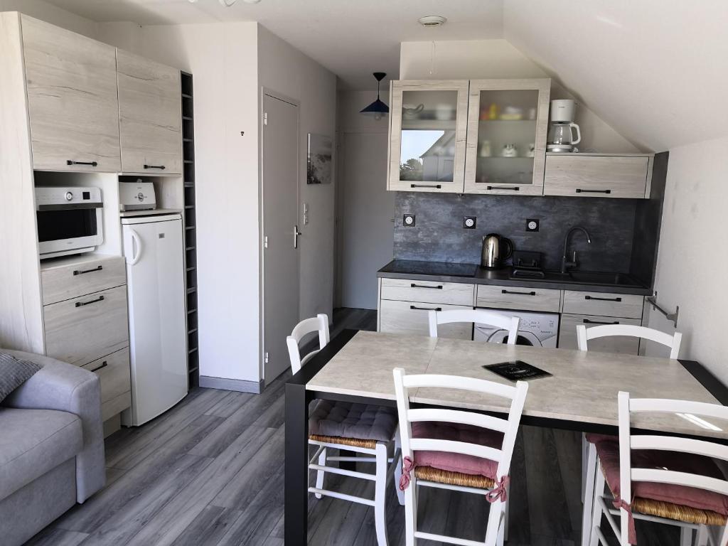 uma cozinha com mesa e cadeiras num quarto em Appartement fonctionnel et chaleureux proche mer em Le Croisic