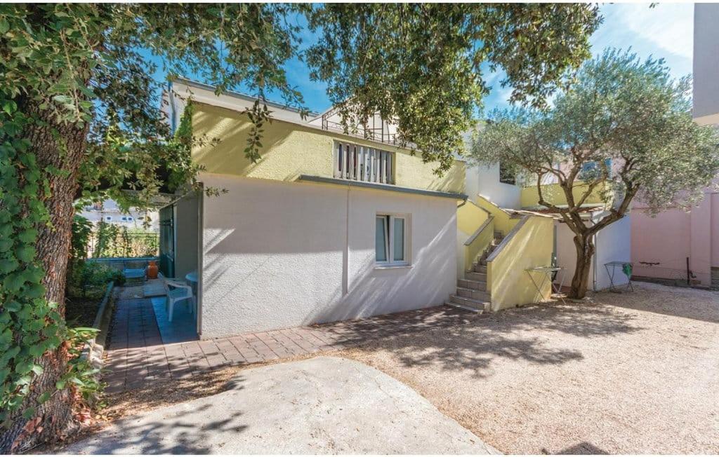 a white house with a tree in front of it at Apartmani Andrija in Pakoštane