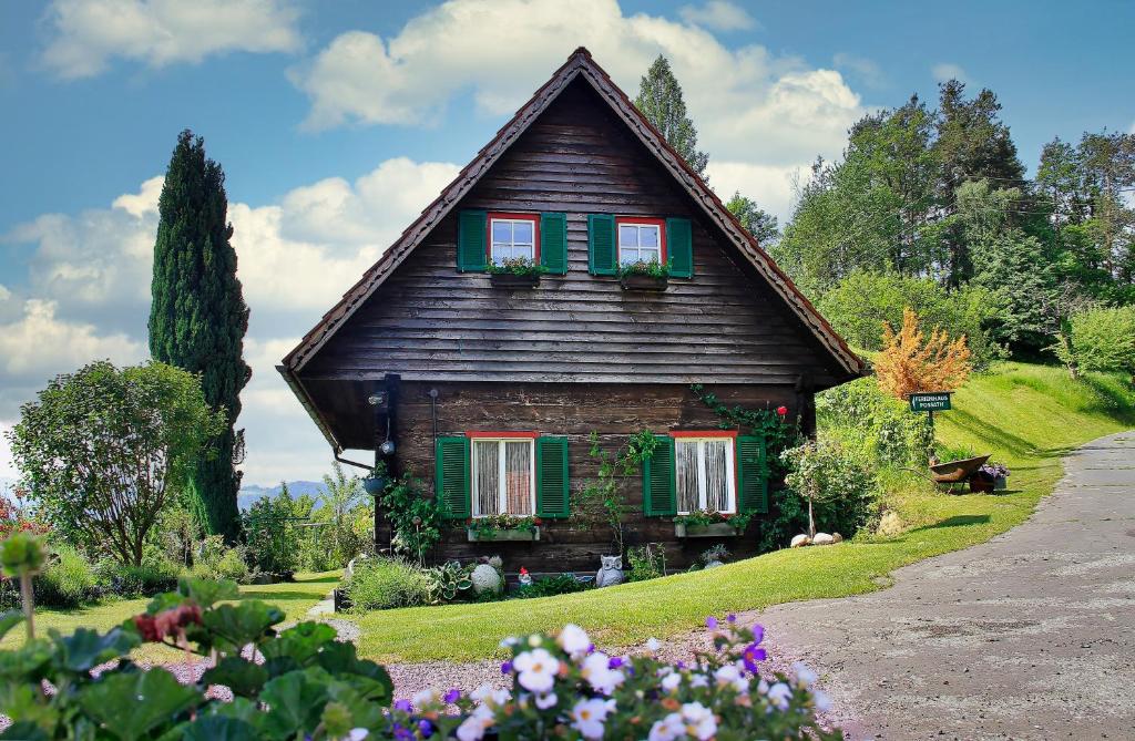 una casa con persiane verdi e fiori di fronte di Ferienhaus Possath a Leutschach