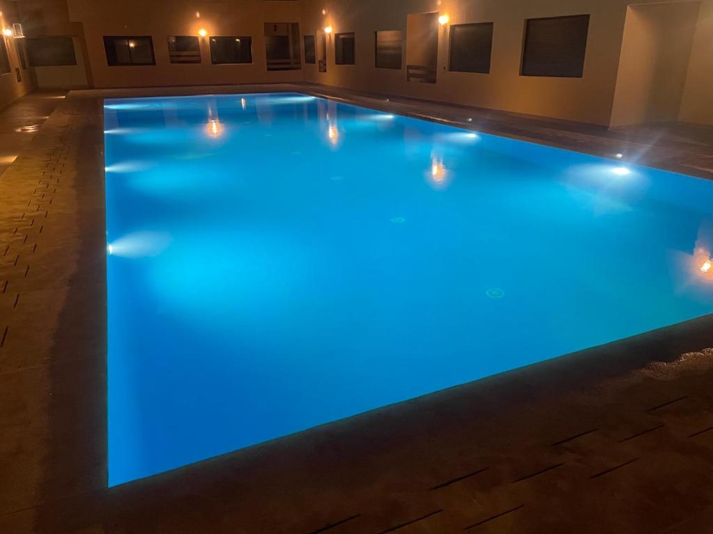 a swimming pool lit up with blue lights at Guéliz l’hivernage nour5 in Marrakesh