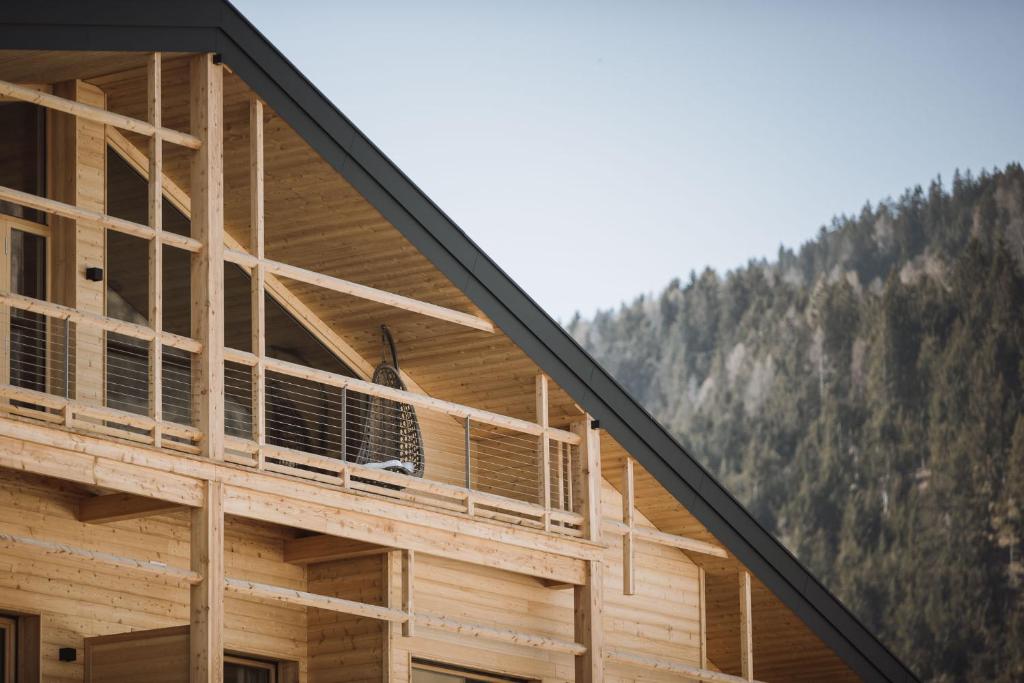 a building with a balcony with a mountain in the background at Hotel Andermax in San Candido