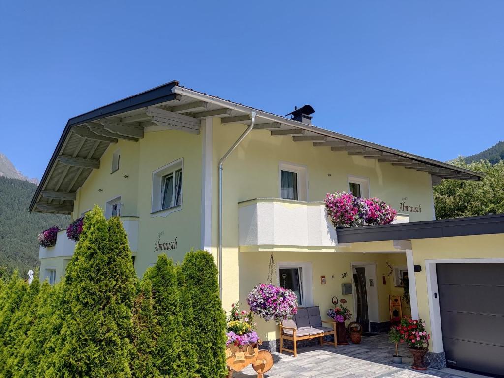 ein Haus mit Blumen auf dem Balkon in der Unterkunft Apart Almrausch in Nauders