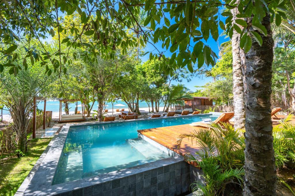 an infinity pool in a resort with trees at Colibri Beach Villas in Ilha de Boipeba