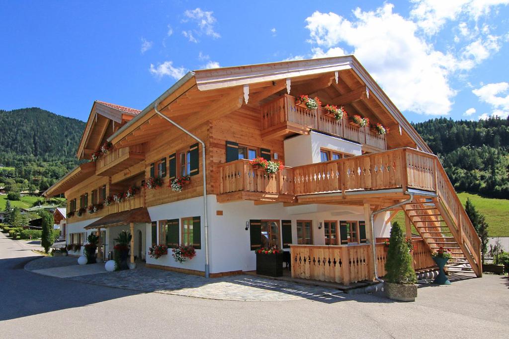 Alpinhotel Berchtesgaden في بيرتشسغادن: منزل خشبي كبير مع شرفة