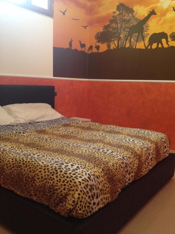 ナポリにあるRelax in Suiteのベッドルーム1室(ヒョウ柄のベッド1台、壁に絵画付)