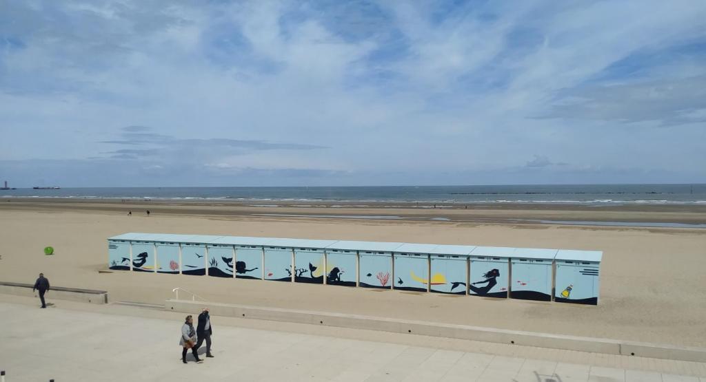 un bâtiment avec un tableau sur une plage dans l'établissement Magnifique Vue mer pour ce T2 totalement rénové classé meublé de tourisme 3 etoiles, à Dunkerque