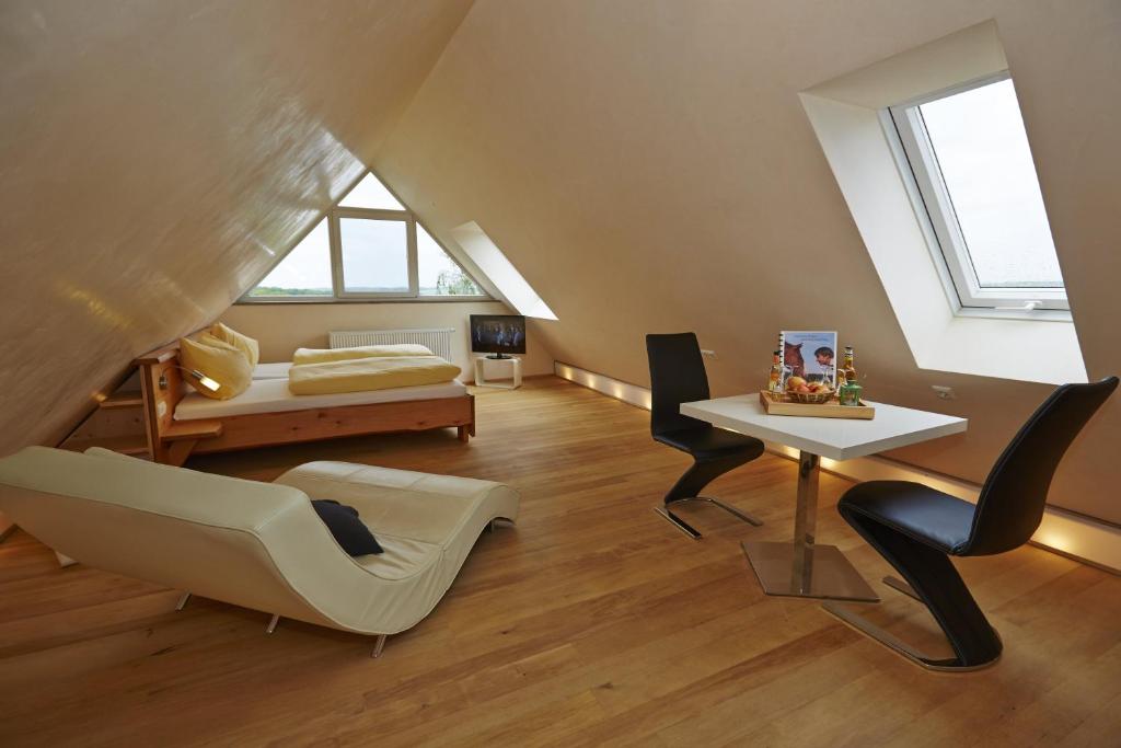 ein Wohnzimmer im Dachgeschoss mit einem Tisch und einem Sofa in der Unterkunft Urlaubsreiterhof Trunk in Igersheim