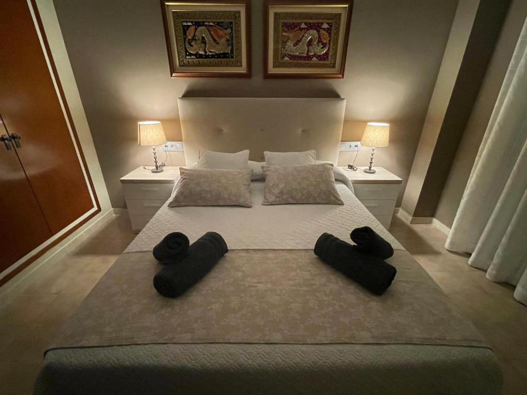 um quarto com uma cama grande e almofadas pretas em Sa Calma em Tossa de Mar